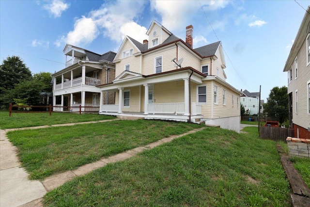 victorian-style house featuring a porch and a front yard