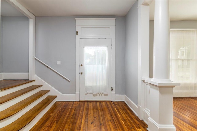 foyer with dark hardwood / wood-style flooring and ornate columns