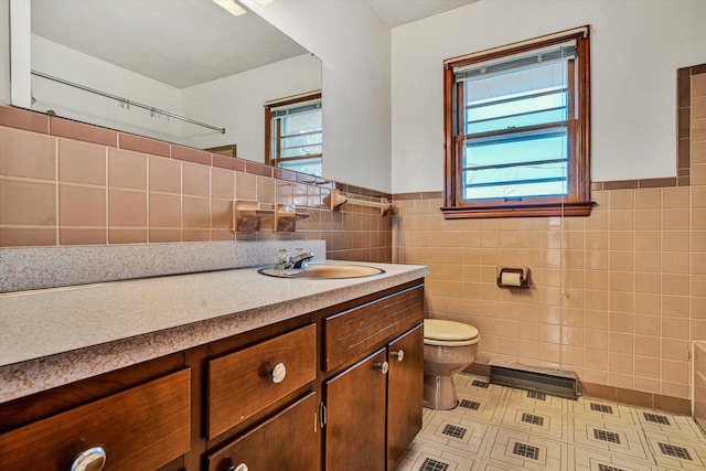 bathroom featuring vanity, tile walls, toilet, and a healthy amount of sunlight