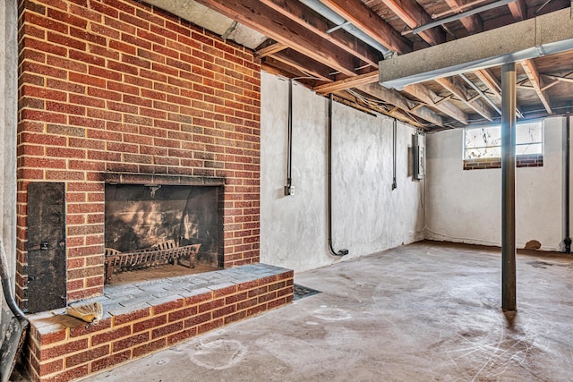 basement featuring a brick fireplace and electric panel