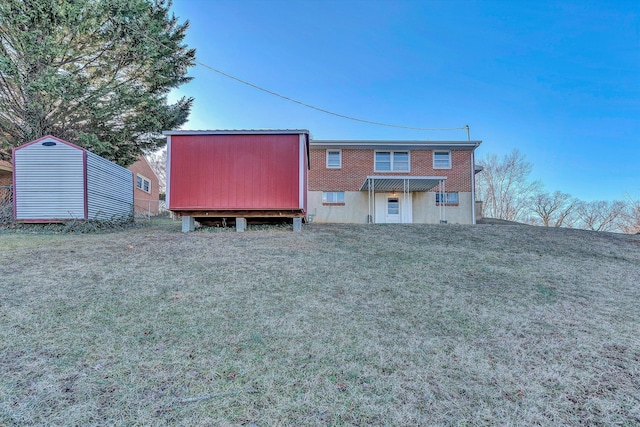 rear view of property featuring a storage shed and a yard