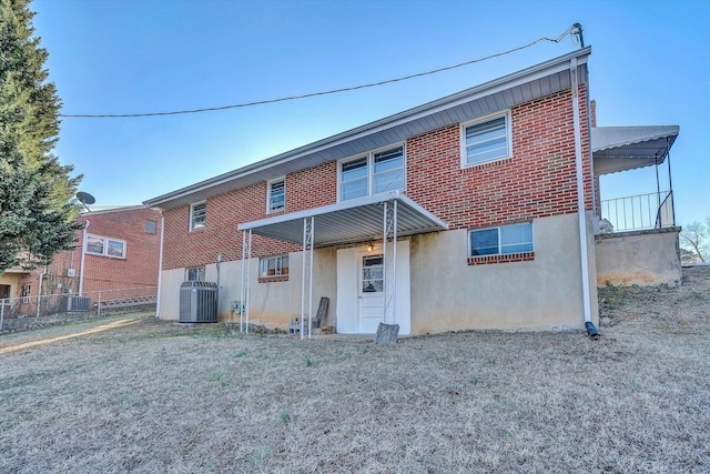 back of house featuring a lawn and central air condition unit