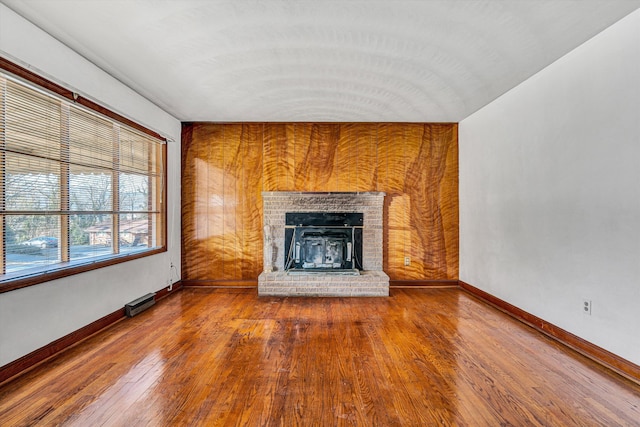 unfurnished living room featuring hardwood / wood-style flooring, a fireplace, and vaulted ceiling