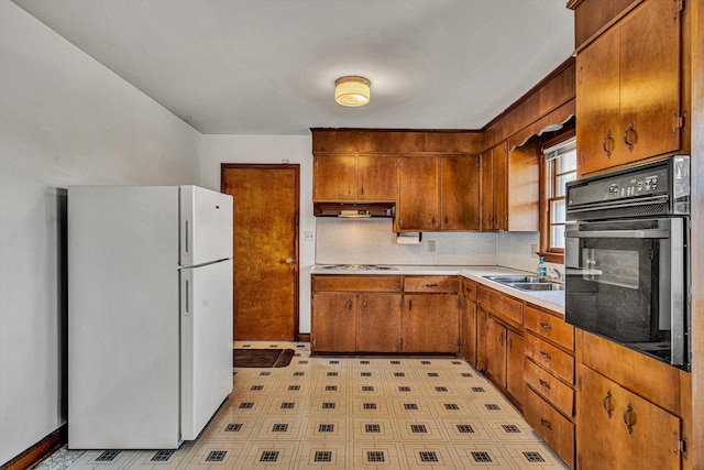 kitchen featuring sink, gas stovetop, tasteful backsplash, white fridge, and oven