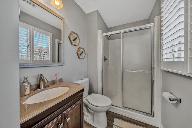 bathroom featuring vanity, toilet, and an enclosed shower