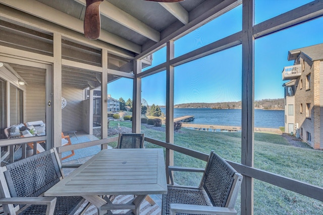 sunroom featuring a water view