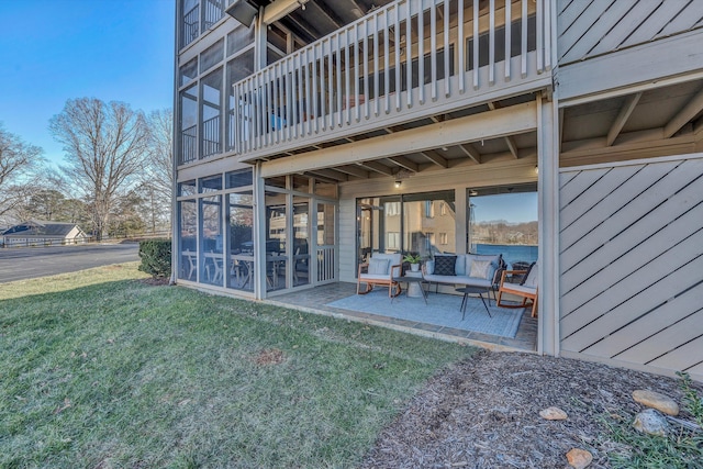 back of house with a patio and a lawn