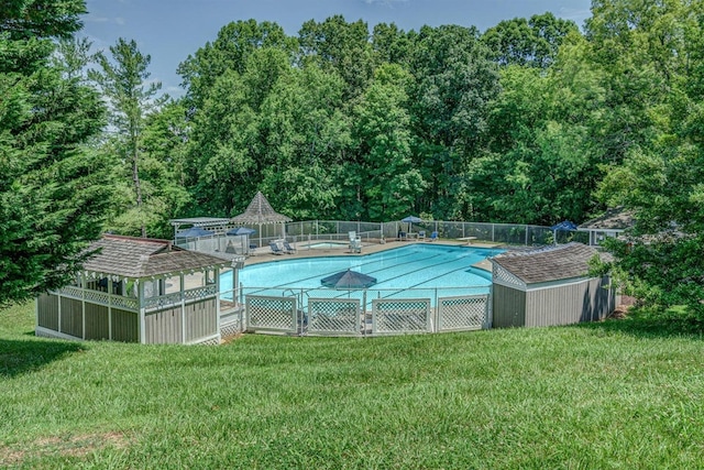 view of swimming pool with a gazebo, a yard, and a shed