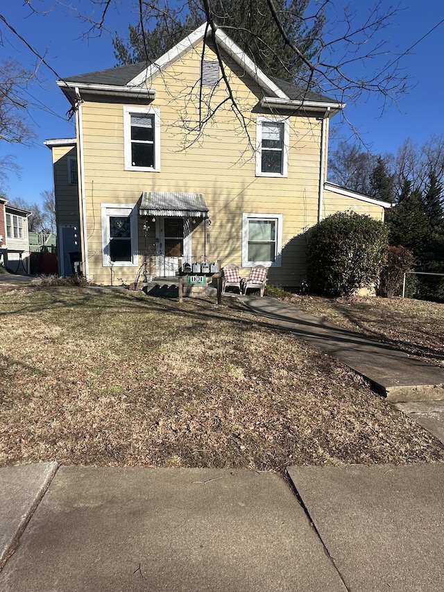 rear view of house featuring a lawn