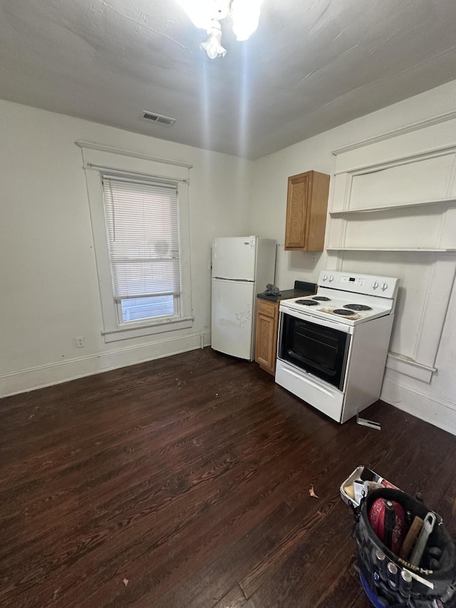 kitchen featuring white appliances and dark hardwood / wood-style flooring