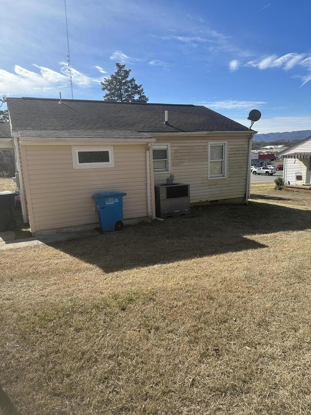 back of property with cooling unit and a lawn