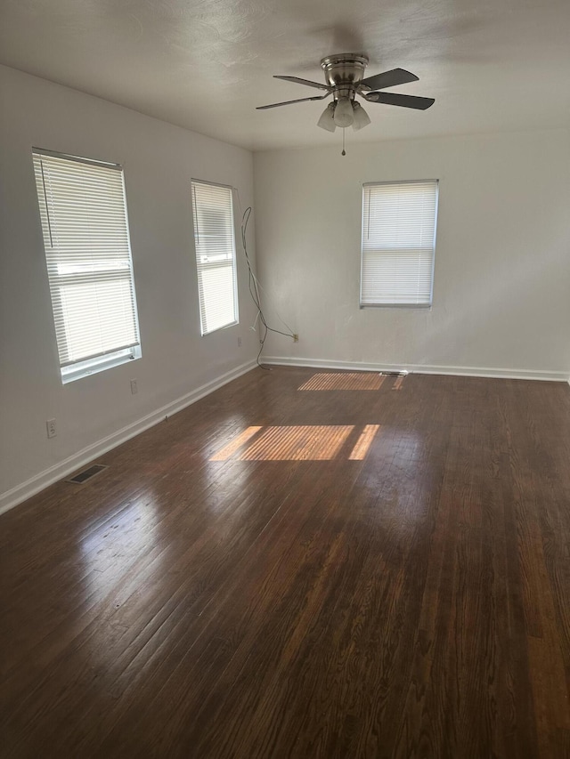 unfurnished room with ceiling fan and dark hardwood / wood-style flooring