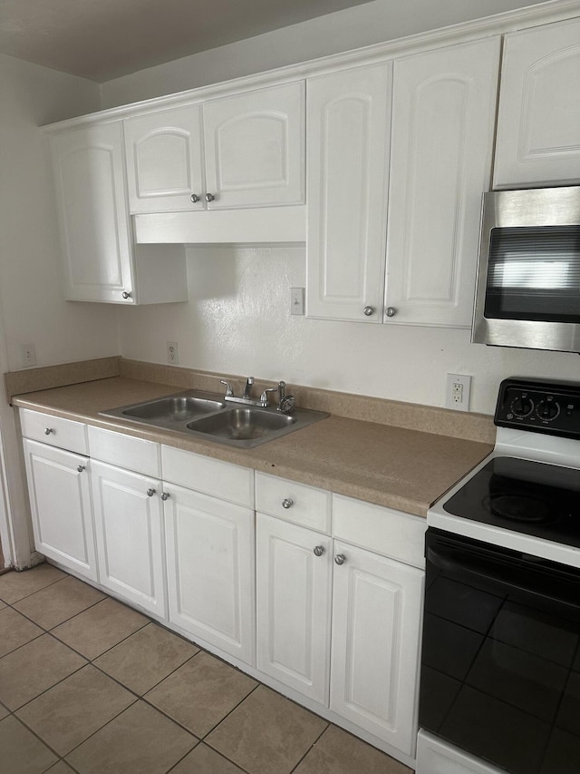 kitchen featuring white cabinets, light tile patterned flooring, sink, and electric range