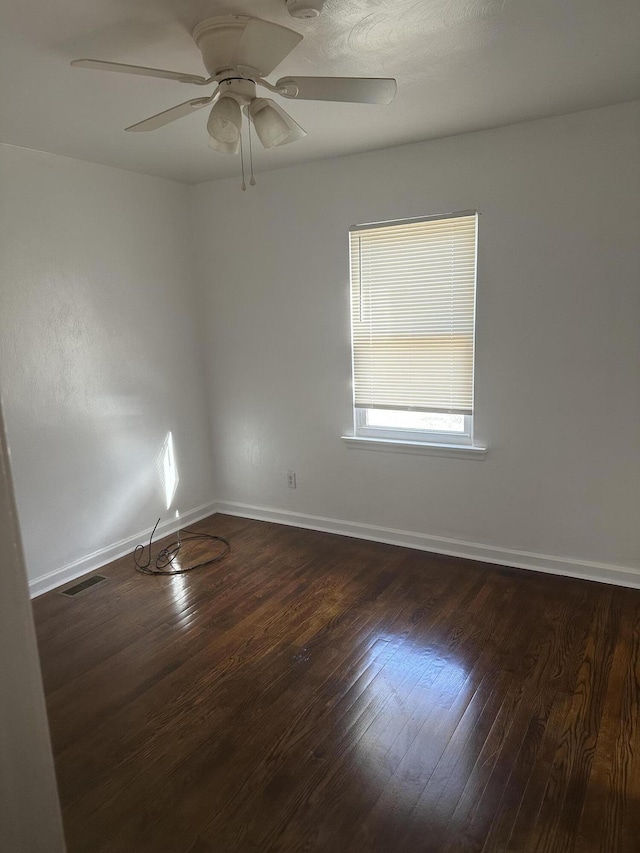 empty room with ceiling fan and dark hardwood / wood-style flooring