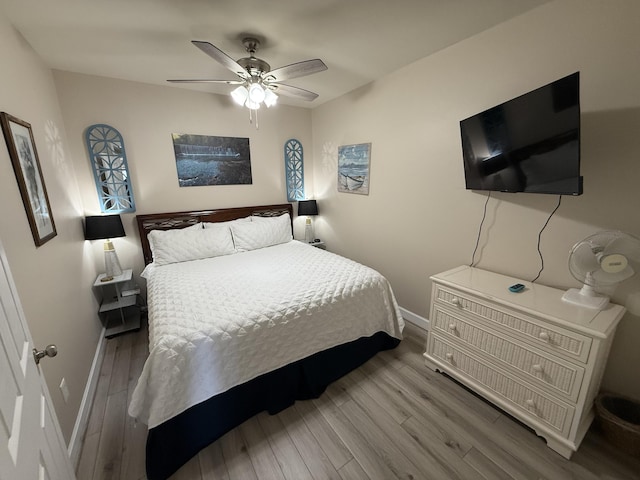 bedroom featuring ceiling fan, baseboards, and wood finished floors