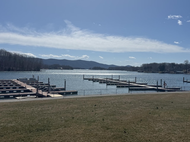 dock area featuring a lawn and a water and mountain view