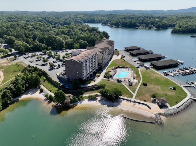 birds eye view of property with a water view and a wooded view