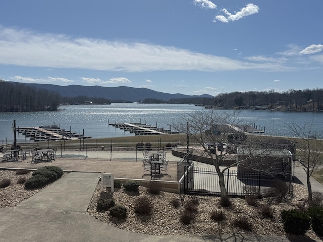 exterior space with a water view and fence