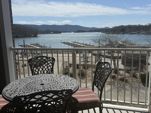 balcony featuring a boat dock and a water and mountain view