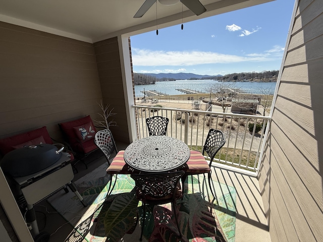 balcony featuring ceiling fan and a water and mountain view