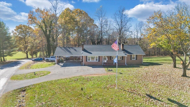 ranch-style house featuring a carport and a front lawn