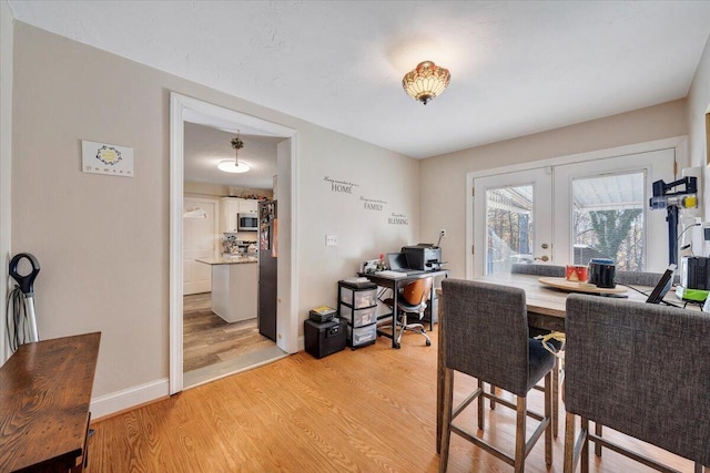 dining area with light hardwood / wood-style floors and french doors