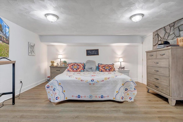 bedroom with light hardwood / wood-style flooring and a textured ceiling