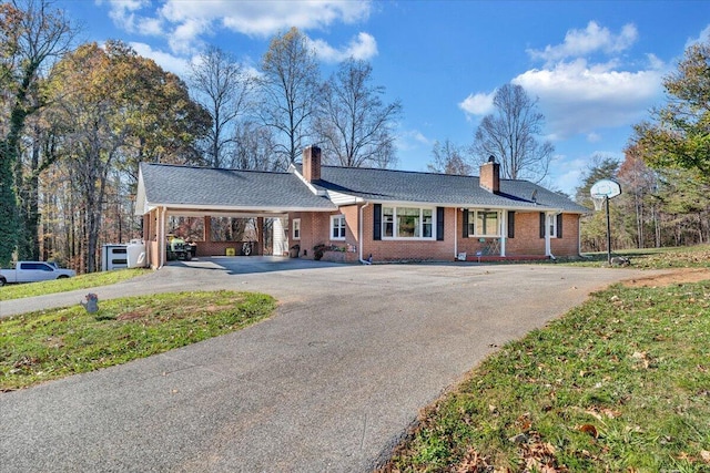 ranch-style home featuring a carport and a front yard