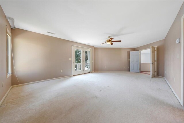 unfurnished room featuring light carpet, french doors, and ceiling fan