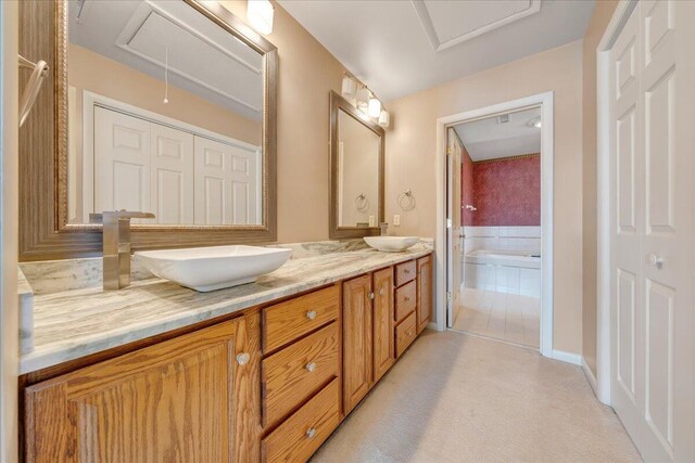 bathroom featuring vanity and a relaxing tiled tub