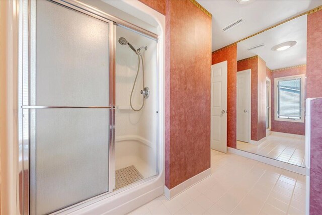 bathroom with a shower with shower door and tile patterned flooring