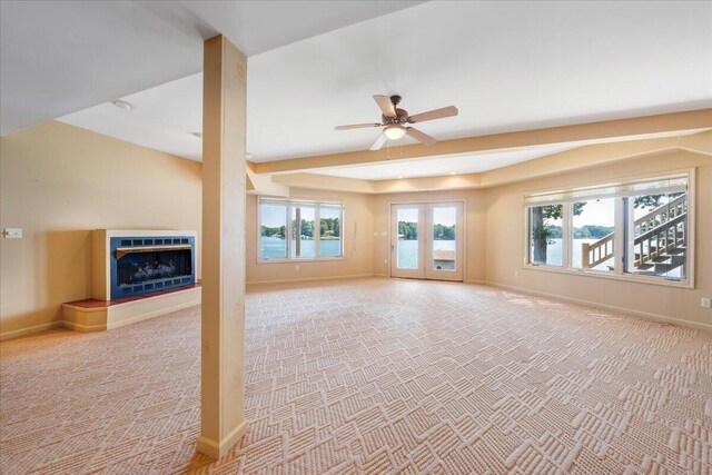 unfurnished living room featuring light carpet, ceiling fan, and french doors