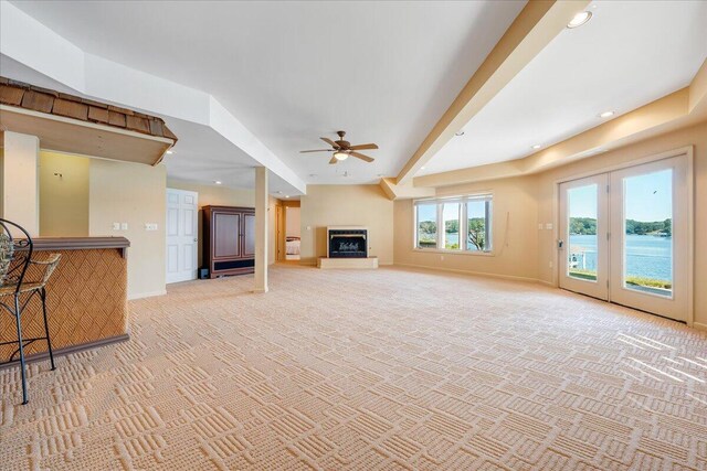 living room featuring a water view, ceiling fan, and carpet