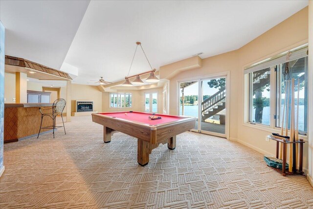 rec room featuring a water view, light colored carpet, pool table, and ceiling fan