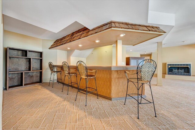 kitchen featuring a kitchen breakfast bar, kitchen peninsula, and light carpet