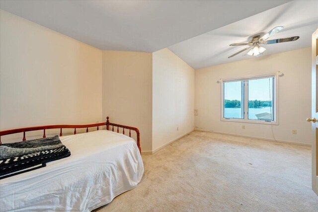 carpeted bedroom featuring a water view and ceiling fan