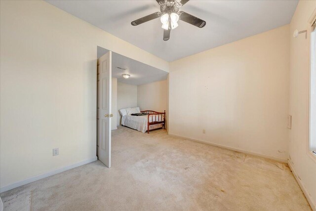 unfurnished bedroom with light carpet and ceiling fan