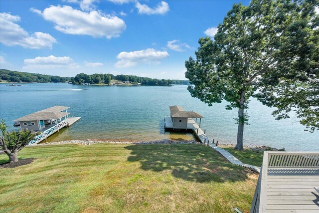 view of dock with a water view and a lawn