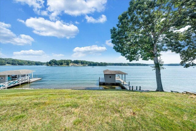 view of dock featuring a water view and a lawn