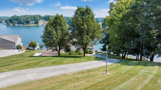 view of property's community with a water view and a lawn