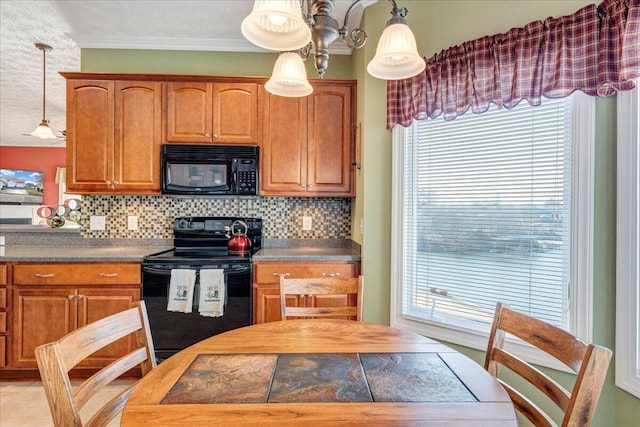 kitchen with hanging light fixtures, crown molding, backsplash, and black appliances