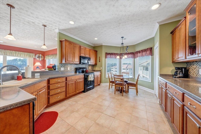 kitchen with sink, a wealth of natural light, pendant lighting, decorative backsplash, and black appliances