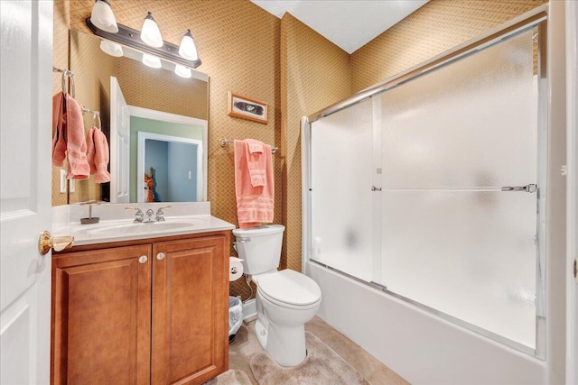 full bathroom featuring vanity, tile patterned flooring, shower / bath combination with glass door, and toilet