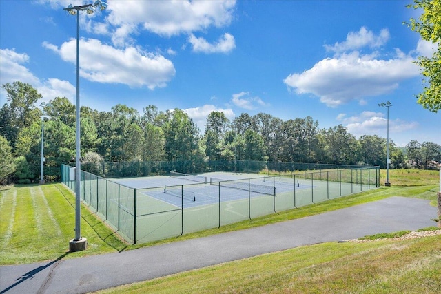 view of sport court with a lawn