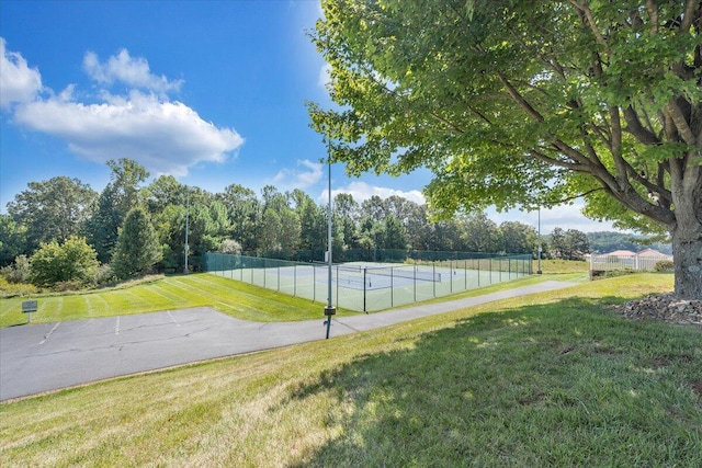 view of basketball court featuring tennis court and a lawn