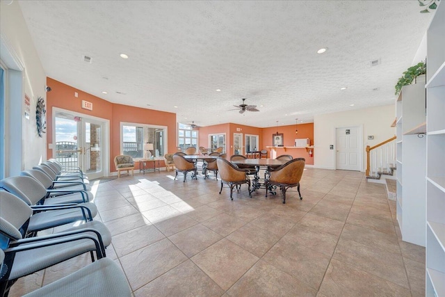 tiled dining room featuring ceiling fan, a textured ceiling, and french doors