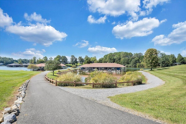 surrounding community featuring a water view and a lawn