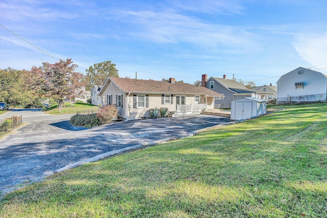 view of front facade with a storage shed and a front lawn