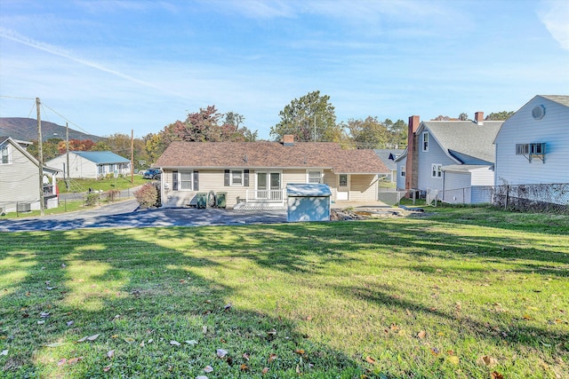 rear view of property featuring a patio area and a lawn