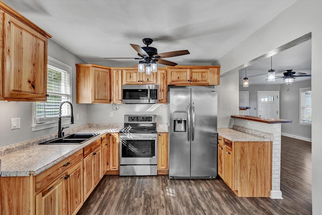 kitchen featuring stainless steel appliances, a healthy amount of sunlight, sink, and pendant lighting